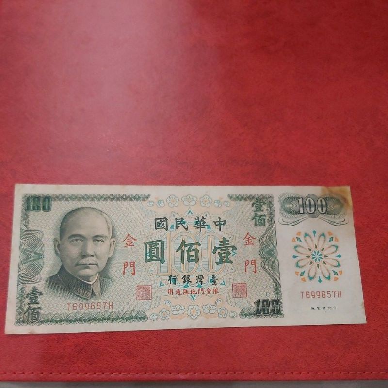 民國61年100元紙鈔，正面右上角有破角，膠帶黏貼