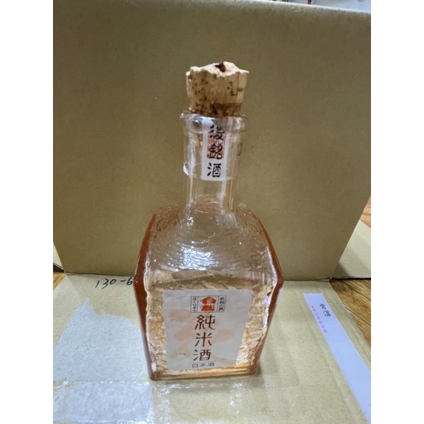 晶瑩剔透的粉色日本米酒空酒瓶。