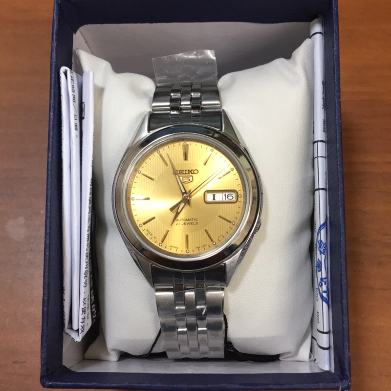 全日本製。SEIKO精工牌 5號 機械錶 自動上鍊。夜光。香檳金錶盤。不鏽鋼錶帶。(SNKL21J1)。