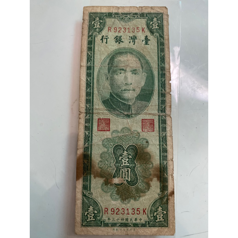 121、h207)43年1元鈔，很破舊，有貼膠帶，有大片污漬，如圖這張