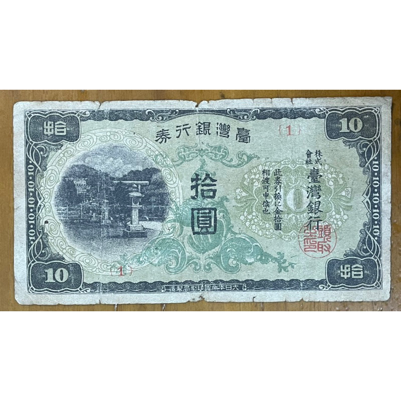 1944年台灣銀行券拾圓昭和丁券已使用現地刷綠花紅字背金鵄(罕見組號1台銀水印)