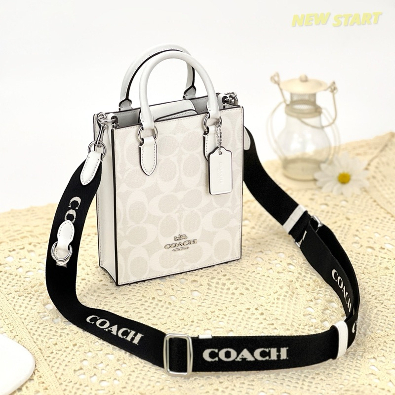 【New START精品服飾-員林】Coach North South 冰川白 字母寬背帶 琴譜包 斜背包